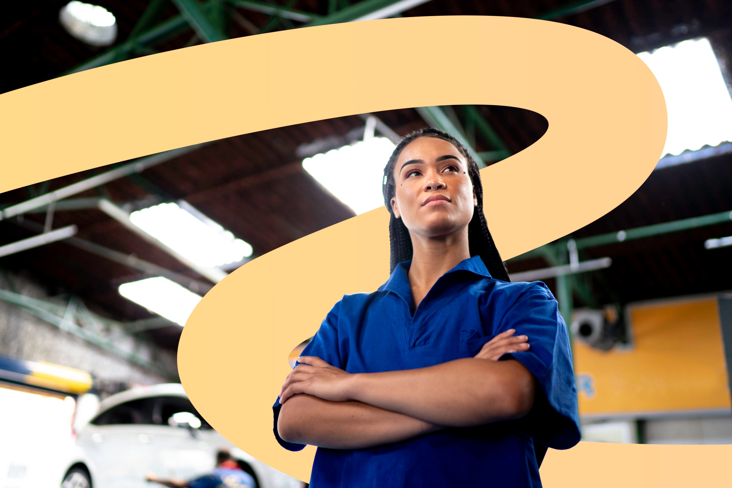 Low angle of a confident mechanic standing with arms crossed, looking away